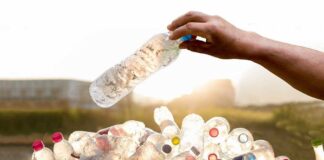 hand throwig bottle into a pile of bottles