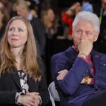 Two people sitting in a crowded event.
