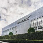 SpaceX building with logo and rocket in front.