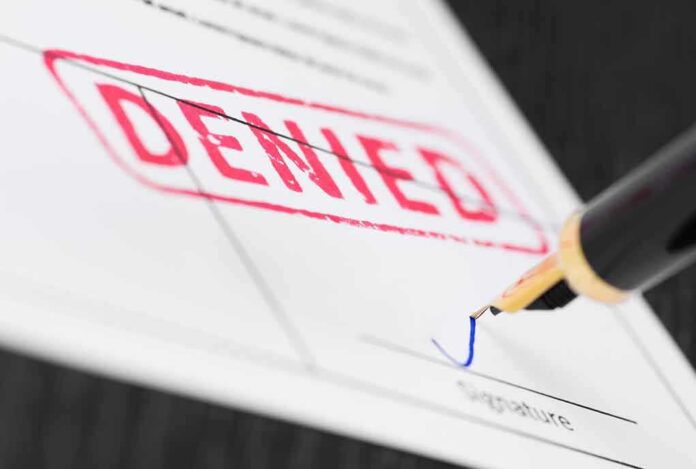 1058833358 featured image Denied stamp on a document with pen.