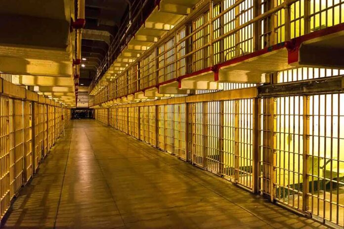 1231860007 featured image Empty hallway between rows of prison cells.