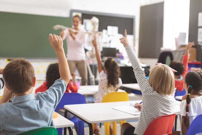1352177357 featured image Children raising hands in classroom.