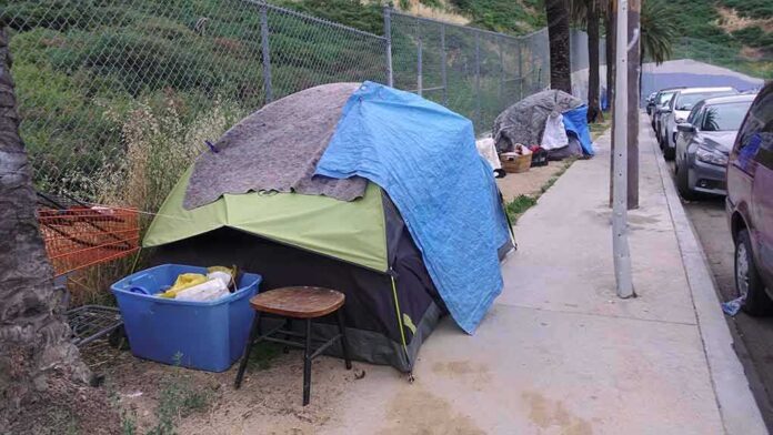 1392494762 featured image Tents and belongings set up along sidewalk.