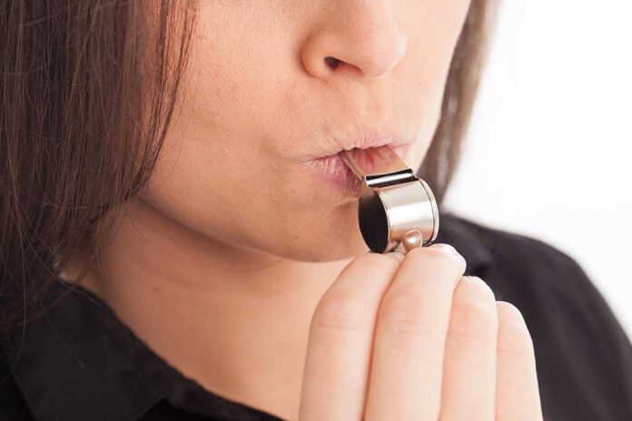1455310238 featured image Person blowing a silver whistle close-up.