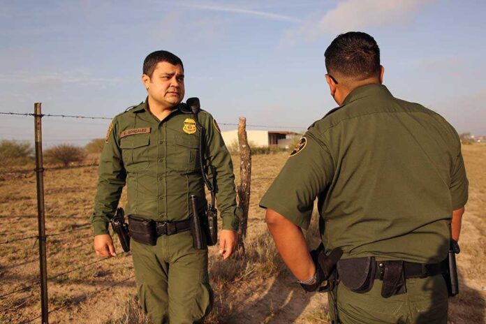 1641270949 featured image Two uniformed officers standing outdoors near a fence.