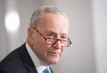 Chuck Schumer in profile with glasses sliding down nose.
