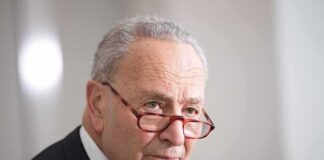 Chuck Schumer in profile with glasses sliding down nose.