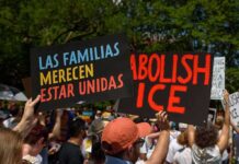 People holding protest signs outdoors against ICE policies