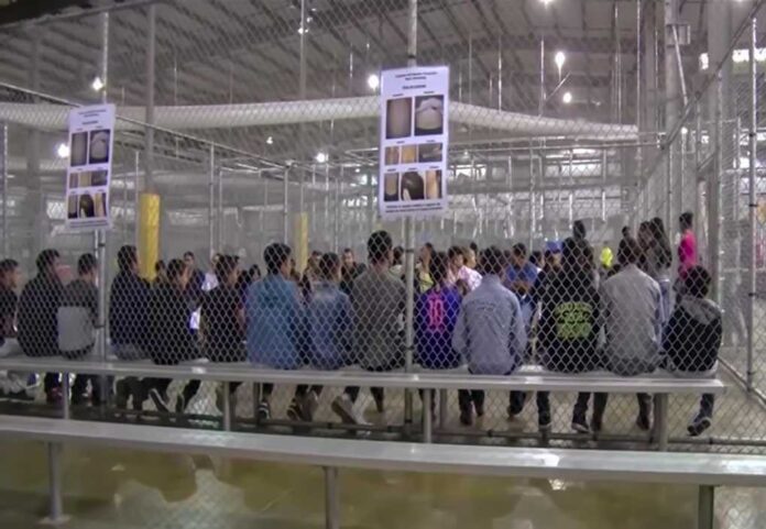 1229072206 featured image People sitting on benches inside a fenced facility.