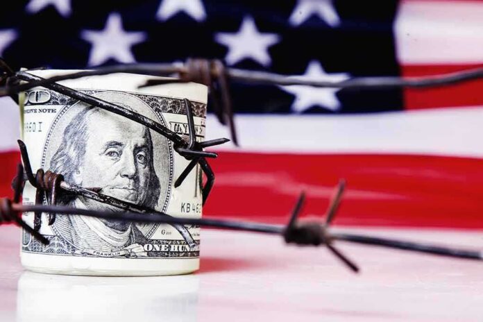 1828091912 featured image Hundred dollar bill wrapped in barbed wire flag background