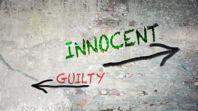 1877059255 featured image a stucco wall with the word inncent written in green paint, and the word guilty written in red paint