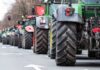 Tractors lined up on a city street.