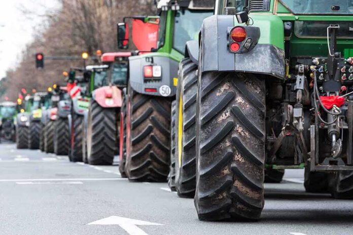 2134418091 featured image Tractors lined up on a city street.