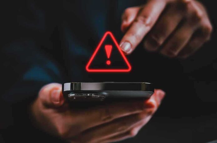 2341991067 featured image Finger touching phone with red warning symbol.