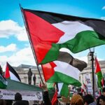 Palestinian flags waving at protest rally outdoors day