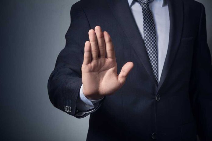 611111144 featured image Businessman raising hand to signal stop gesture.