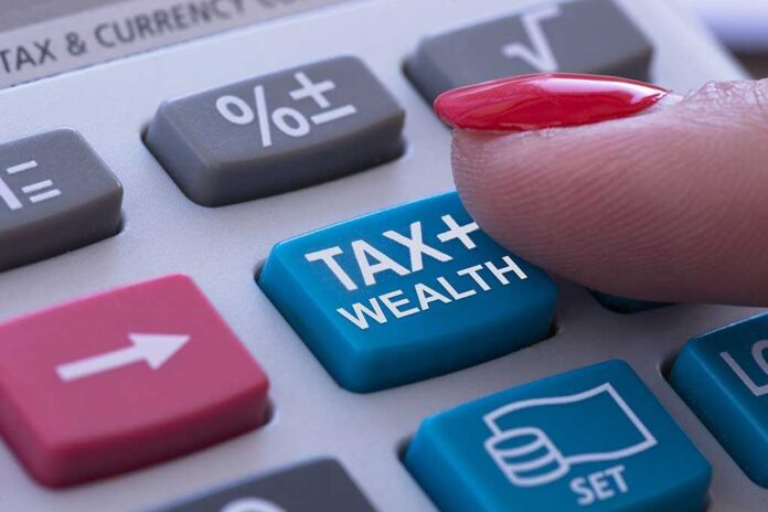 1762066592 featured image Finger pressing calculator tax and wealth button