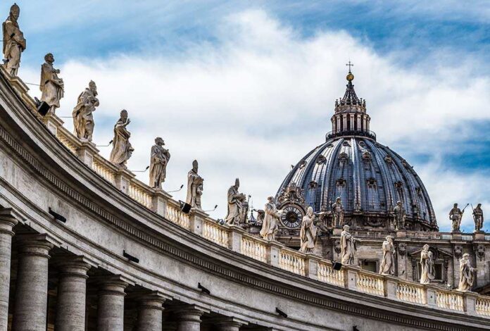 368201633 featured image St. Peter's Basilica dome with statues and clouds.