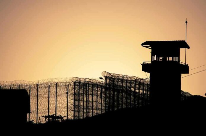 442645978 featured image Sunset behind prison fence and guard tower