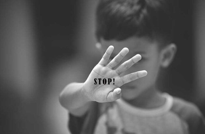 754809316 featured image Child holding up hand with STOP written on palm.