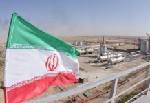 Iranian flag near an industrial gas refinery