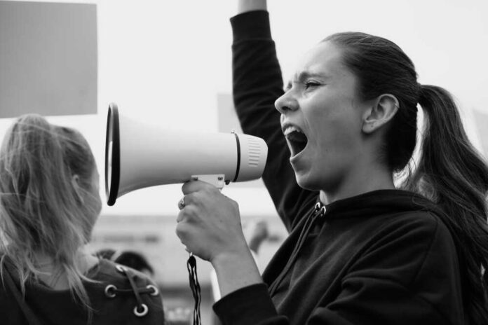 1238112664 featured image Person shouting into megaphone at protest rally