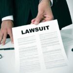 Person holding a document labeled Lawsuit