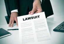 Person holding a document labeled Lawsuit