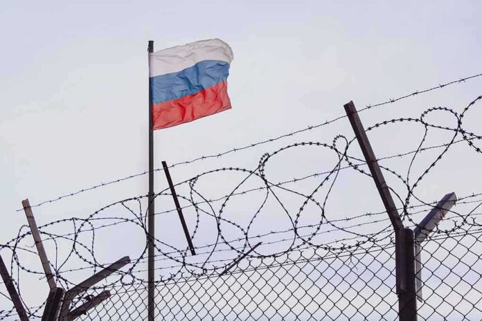 2148395873 featured image Barbed wire fence with Russian flag in background