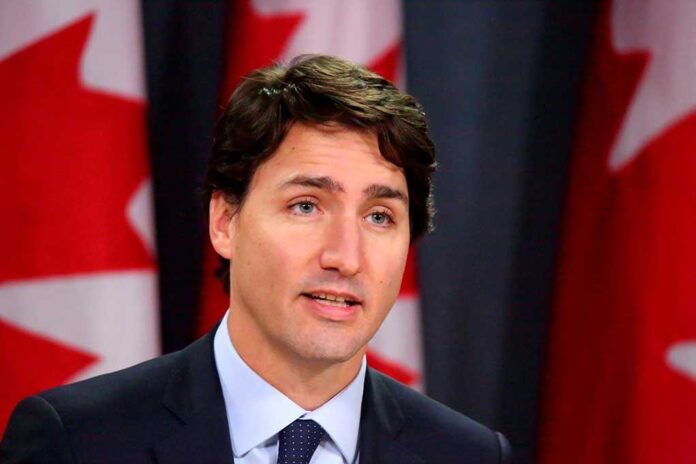 Man speaking in front of Canadian flags