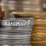 Stack of coins labeled funding with other coins stacks