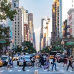 Busy city street with pedestrians and cars.