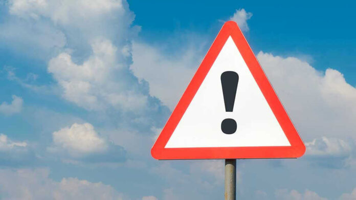 1783780781 Warning sign with exclamation mark against cloudy sky