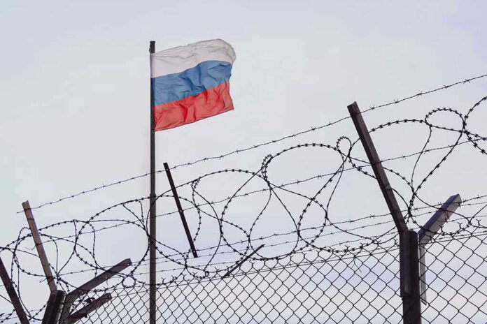 Flag above barbed wire fence
