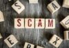 Wooden blocks spell SCAM on a rustic surface