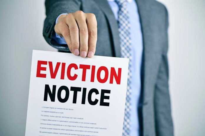 354121799 Man holding eviction notice in hand