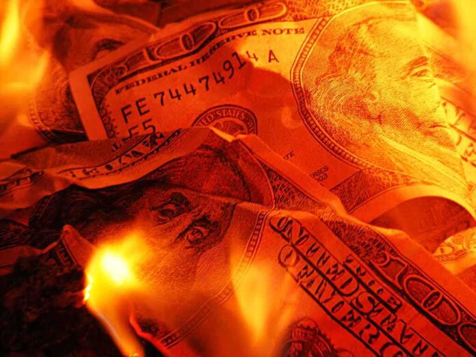 Burning US dollar bills surrounded by flames