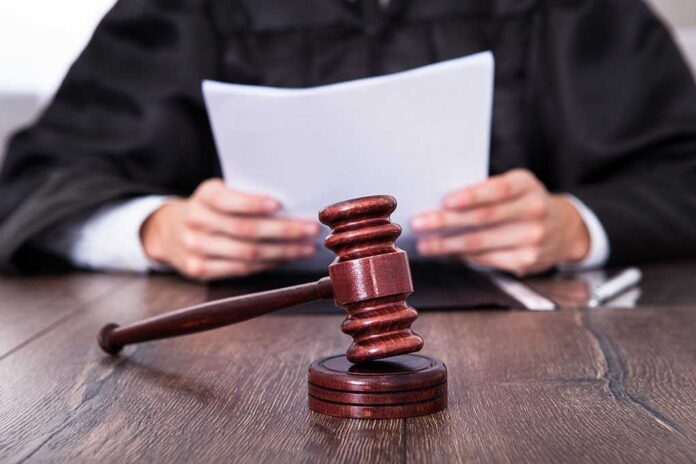shutterstock_164106293.jpg A judge holding documents with a gavel in the foreground
