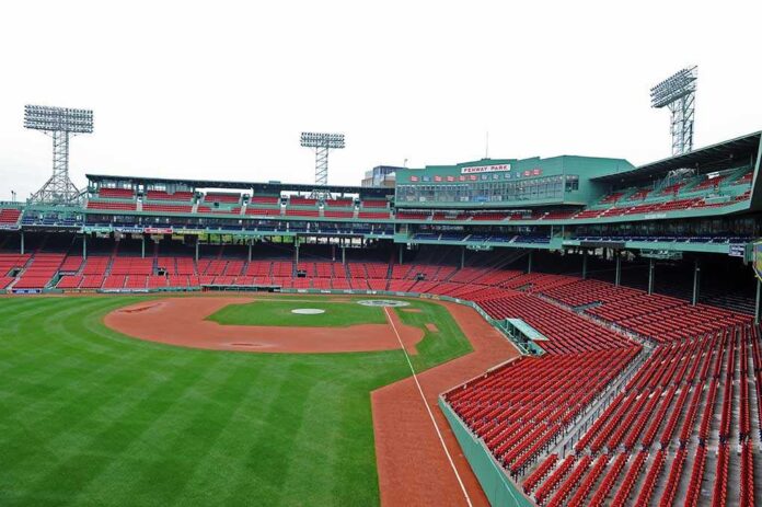 View of an empty Fenway Park baseball stadium with green grass and red seats
