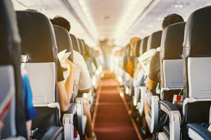 Passengers seated inside an airplane cabin.