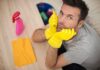 Man in yellow gloves looking frustrated while preparing to clean