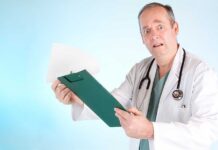 A doctor in a white coat looking surprised while holding a clipboard