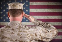 A soldier in uniform saluting in front of the American flag