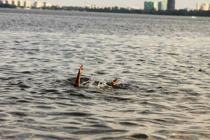 1828334342 Persons hand reaching out from the water.