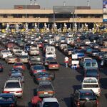 California DMV Ignites Fury—Undocumented Driver Disaster A crowded parking lot filled with cars near a border crossing
