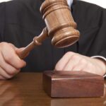Repeat Offender Murders Again — OVER 40 ARRESTS! A judge holding a gavel above a wooden block