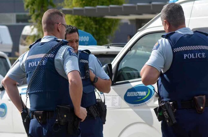 shutterstock_177247016.jpg Three police officers discussing near a police vehicle