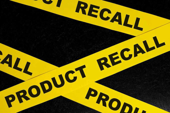 2263803439 Yellow tape with product recall text on black background.