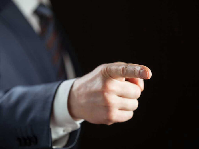 128319779 Person pointing with finger, wearing a suit.
