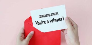 Hands holding a congratulations card and a red envelope